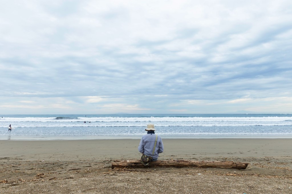 一人で海を見ている男性
